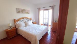 una camera da letto con un letto con un piumone bianco di Vv - Casa Clary -Finca Medina ad Alojera
