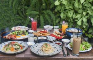 a table topped with plates of food and drinks at Merry Land Hotel Da Nang in Danang
