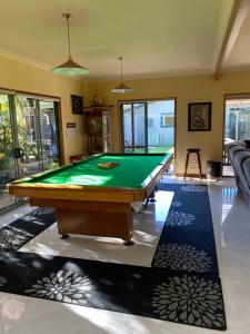 a pool table in a living room with a green at Abel Tasman Marahau in Marahau