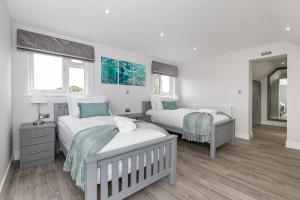 a bedroom with two beds and a mirror at Maple Lodge in Earley