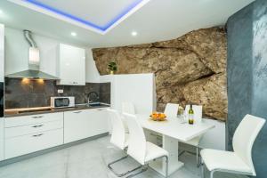 a kitchen with a white table and white chairs at Hidden Gem Apartment in Molunat