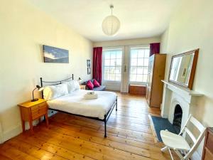 - une chambre avec un lit et une cheminée dans l'établissement Incredible St Andrew's Sq - 2 bed in the sky, à Édimbourg