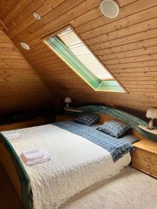 a bedroom with a bed in a wooden attic at B&B Chardas in Bük