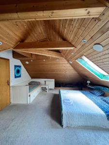 a large room with a bed and a wooden ceiling at B&B Chardas in Bük