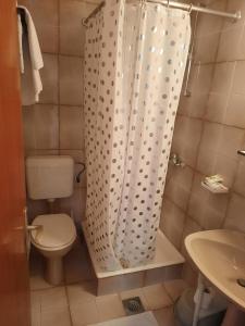 a bathroom with a toilet and a shower curtain at Old town rooms in Rab