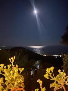 een volle maan boven de oceaan in de nacht bij Alex Boutique Hotel in Himare