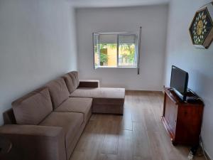 uma sala de estar com um sofá e uma televisão em Casa Brito Aguiar em Angra do Heroísmo