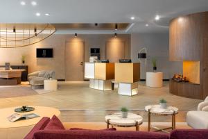 eine Lobby mit Sofas und Tischen in einem Gebäude in der Unterkunft The Emporium Hotel Plovdiv MGallery Collection in Plowdiw