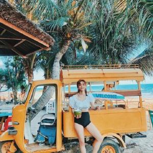 a woman sitting in a golf cart on the beach at Merry Land Hotel Da Nang in Danang