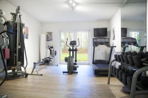 a gym with treadmills and machines in a room at Sunday Hotel des Nordens in Flensburg