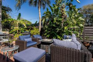 a patio with wicker chairs and tables and palm trees at Spiritual Oasis! The perfect location for those who have a flair for the healing arts and an eclectic, creative style and sensibility.  in Sarasota