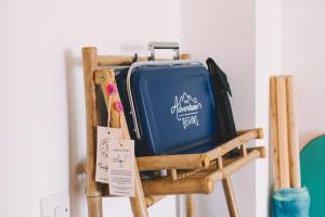 a blue suitcase sitting on a wooden chair at Pentire Point - Fully Equipped Eco Escape in Crantock