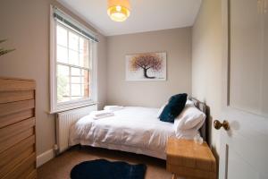 a small bedroom with a bed and a window at Railway Cottage with garden & parking in heart city in Derby