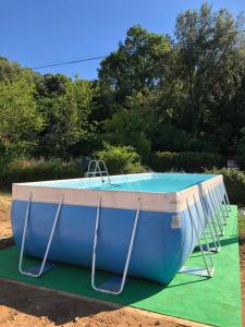 een zwembad met een blauw bad in een tuin bij Maison entière pour 6 personnes dans les Cévennes in Cendras