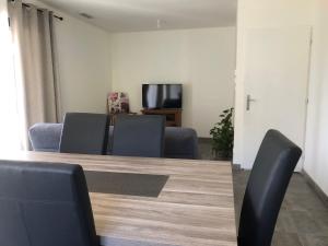 una sala conferenze con tavolo, sedie e TV di Maison entière pour 6 personnes dans les Cévennes a Cendras