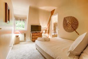 a bedroom with a bed and a flat screen tv at La Côte Fleurie - Five bedrooms garden and Jacuzzi - Tourgéville Plage in Deauville