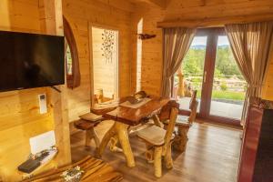 ein Esszimmer mit einem Tisch in einer Blockhütte in der Unterkunft Lake Cottage - Koča ob jezeru in Nazarje