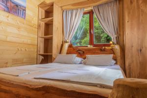 Lake Cottage - Koča ob jezeru في Nazarje: سرير في غرفة خشبية مع نافذة +17 صورة