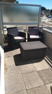 two chairs and a bench on a balcony at Studio calme avec terrasse vue mer in Pléneuf-Val-André