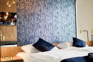 A bed or beds in a room at ELLBy Apartman - PENTHOUSE - hostAID