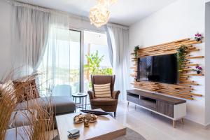 a living room with a flat screen tv on a wall at Lemon Tree 1-BR Apt in Livadia in Larnaka