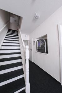 einen Flur mit einer Treppe mit einem TV an der Wand in der Unterkunft 24/7 selfcheckin Schmiedestrasse in Leer