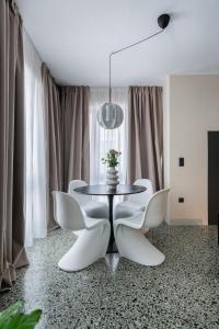 a dining room with a table and white chairs at The Artisan Suites in Athens