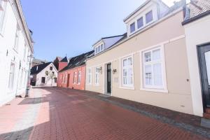 an empty street with white and red buildings at 24/7 selfcheckin Schmiedestrasse in Leer