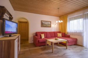 Televízia a/alebo spoločenská miestnosť v ubytovaní Landhaus Alpina