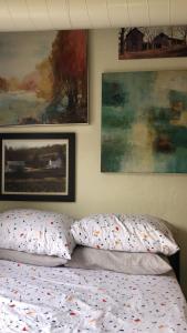 a bed with two pillows and paintings on the wall at Highland Park Pittsburgh in Pittsburgh