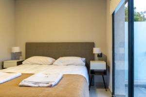 um quarto com uma cama grande e toalhas em Fk Alojamientos San Pedro em San Pedro