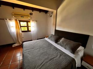 L Otro Pueblo Pampatar في Pampatar: غرفة نوم بسرير ونافذة