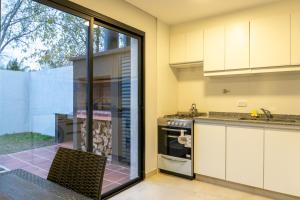uma cozinha com armários brancos e uma porta de vidro deslizante em Fk Alojamientos San Pedro em San Pedro