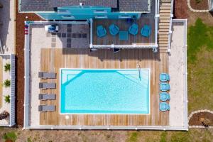 an overhead view of a swimming pool with blue chairs at Oceanview Reserve home in Holden Beach