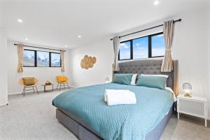 a bedroom with a blue bed with windows at Spa, Mountains & Lake in Queenstown