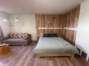 ein Schlafzimmer mit einem Bett und einem Sofa in der Unterkunft OLD SQUARE HOUSE - HIŠA NA STAREM TRGU in Tolmin