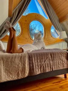 a woman laying on a bed in front of a window at Villa Belweder in Zakopane