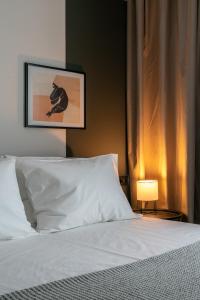 a bedroom with a white bed and a lamp at The Artisan Suites in Athens