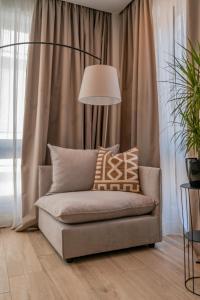 The Artisan Suites في أثينا: أريكة في غرفة المعيشة مع مصباح