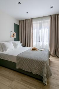 - une chambre avec un lit et une fenêtre avec des rideaux dans l'établissement The Artisan Suites, à Athènes