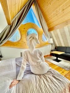 a person sitting on a bed in a room at Villa Belweder in Zakopane