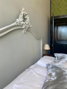 a white bed with a white headboard in a bedroom at Maison de l'Aumance in Meaulne