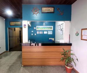 um átrio com um balcão de madeira com uma parede azul em Hotel Serra do Mar em Paranaguá