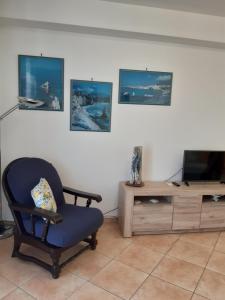 a living room with a chair and a television at A casa di Loretta in Terrasini