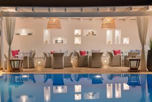 a restaurant with chairs and a swimming pool at Stelia Mare Boutique Hotel in Naousa