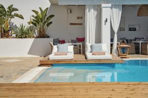 a pool with two lounge chairs next to a house at Stelia Mare Boutique Hotel in Naousa