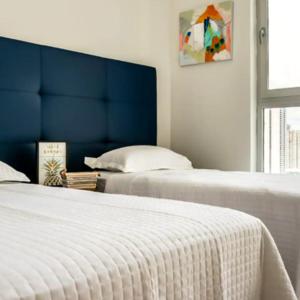 two beds with a blue headboard in a bedroom at Espectacular Apartamento con Piscina en Panamá in Panama City
