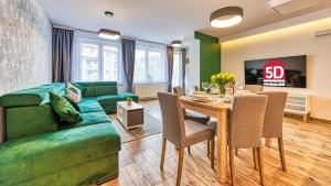 een woonkamer met een groene bank en een tafel bij Apartament PO PRACY z SAUNĄ - 5D Apartamenty in Świeradów-Zdrój