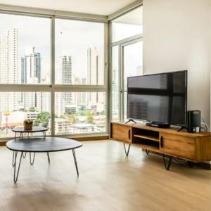 a living room with a large flat screen tv at Espectacular Apartamento con Piscina en Panamá in Panama City