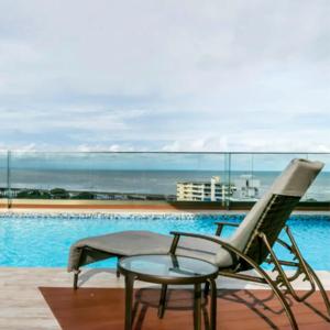 a chair and a table next to a pool at Espectacular Apartamento con Piscina en Panamá in Panama City